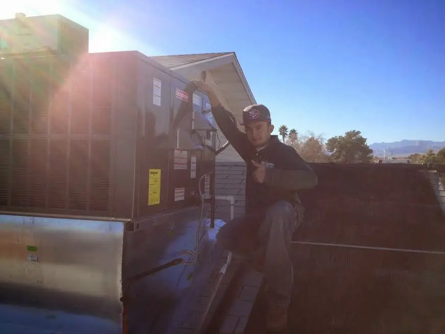 HVAC technician performing AC Tune-Up on a rooftop unit in Berea